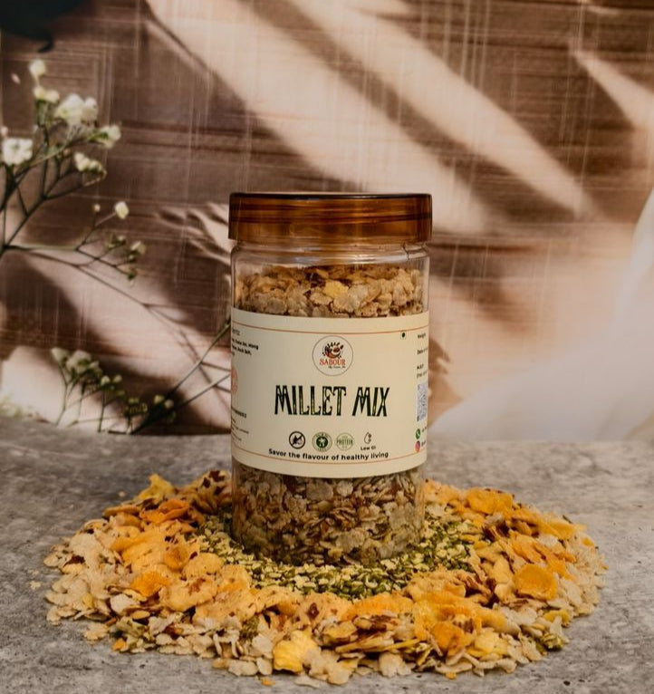 Jar of 'Millet Mix' surrounded by yellow flowers on a wooden surface with a blurred natural background